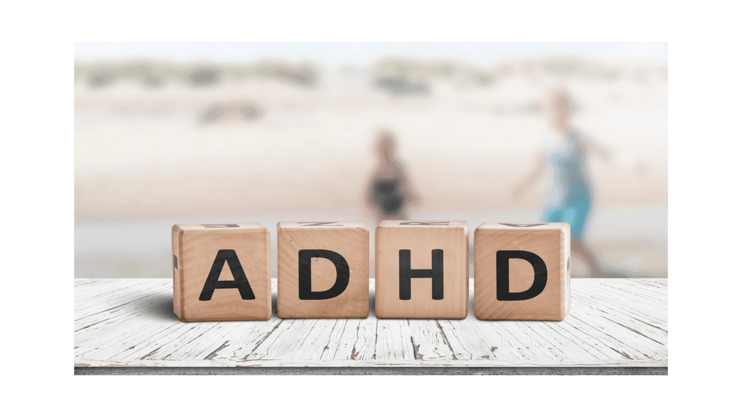 Quattro cubi di legno con le lettere “ADHD” in primo piano; sullo sfondo sfocato si intravedono bambini in movimento all’aperto.